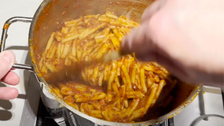 Pasta blandes i tomatsovsen efter kødet er kommet op af gryden med Ragu