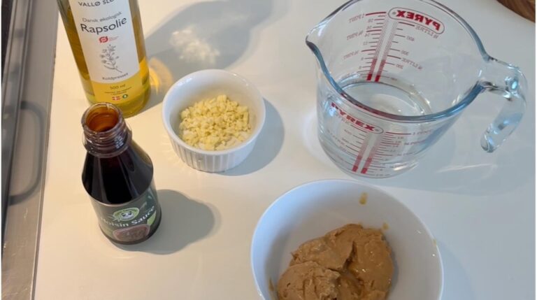  Ingredienser til hjemmelavet peanut hoisin sauce med peanutbutter, hvidløg, hoisin sauce, rapsolie og vand
