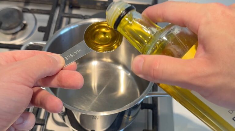 Rapsolie måles af og hældes i gryde som start på peanut hoisin sauce