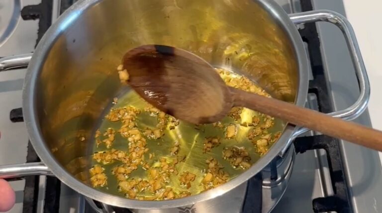 Fint hakket hvidløg svitses i olie som base til peanut hoisin sauce