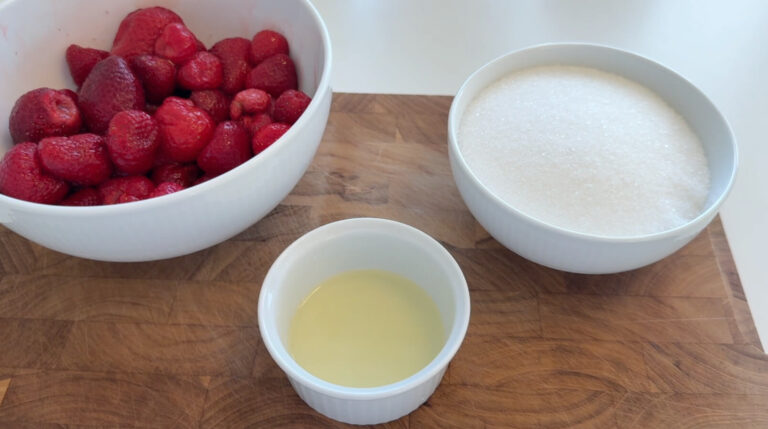 Ingredienser til hjemmelavet jordbærmarmelade med jordbær, sukker og citron
