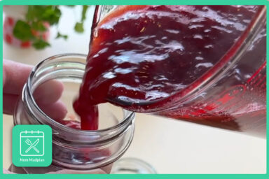 Jordbærmarmelade bliver hældt op i marmelade glas