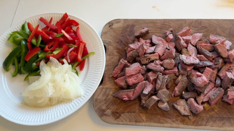 Oksekød fra oksemørbrad skåret i små tern klar til at blive tilsat i Philly cheesesteak sandwichen.