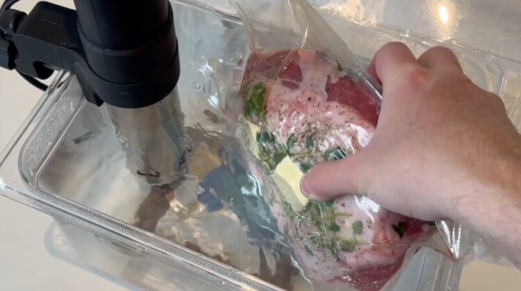     Oksecuvette i vakuumpose sænkes ned i sous vide vandbad ved 55 grader